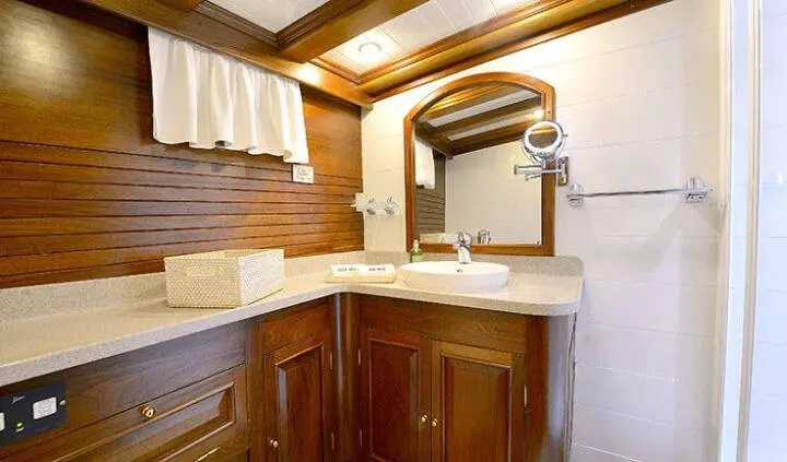 Master cabin with king bed, wood cabinetry, and ensuite bathroom area