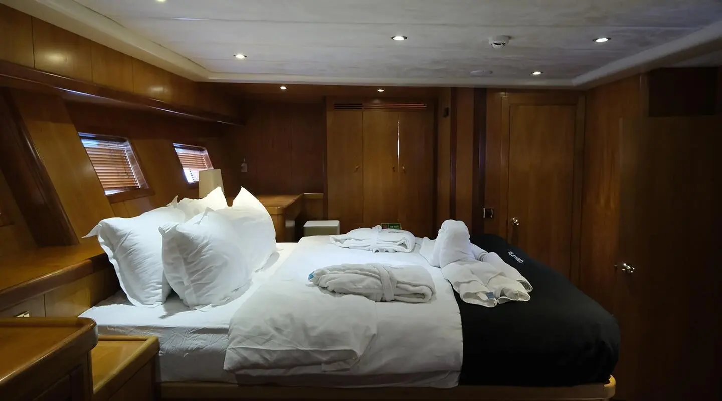 Queen Of Sea yacht bedroom with two single beds and white linens