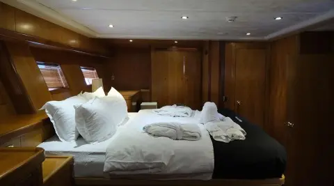 Queen Of Sea yacht bedroom with two single beds and white linens