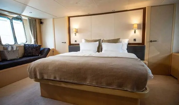 Luxurious master cabin with king bed, brown bedding, and ensuite hint