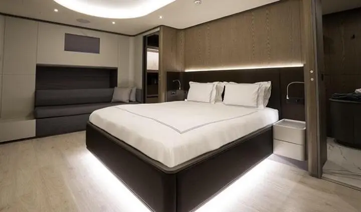Master cabin with king bed, white linens, ensuite bath, soft lighting
