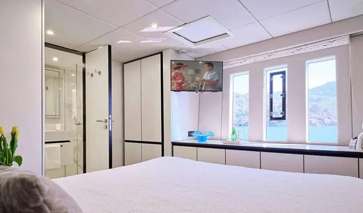 Bedroom aboard Genny yacht, cabin with king bed and neutral décor