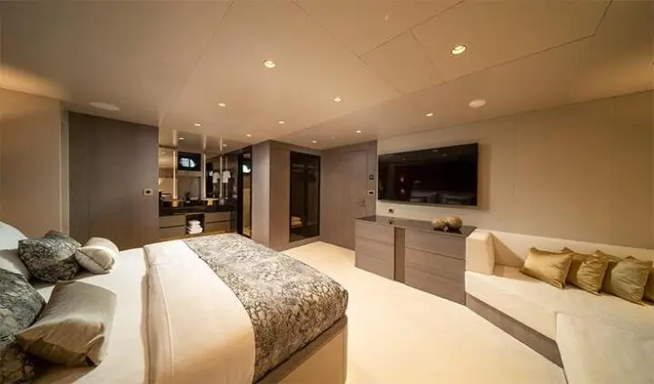 Large bed with bedside decor, TV and seating area visible