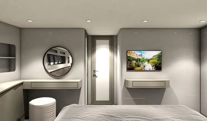 Cabin interior with a king bed, round mirror, TV, and neutral decor