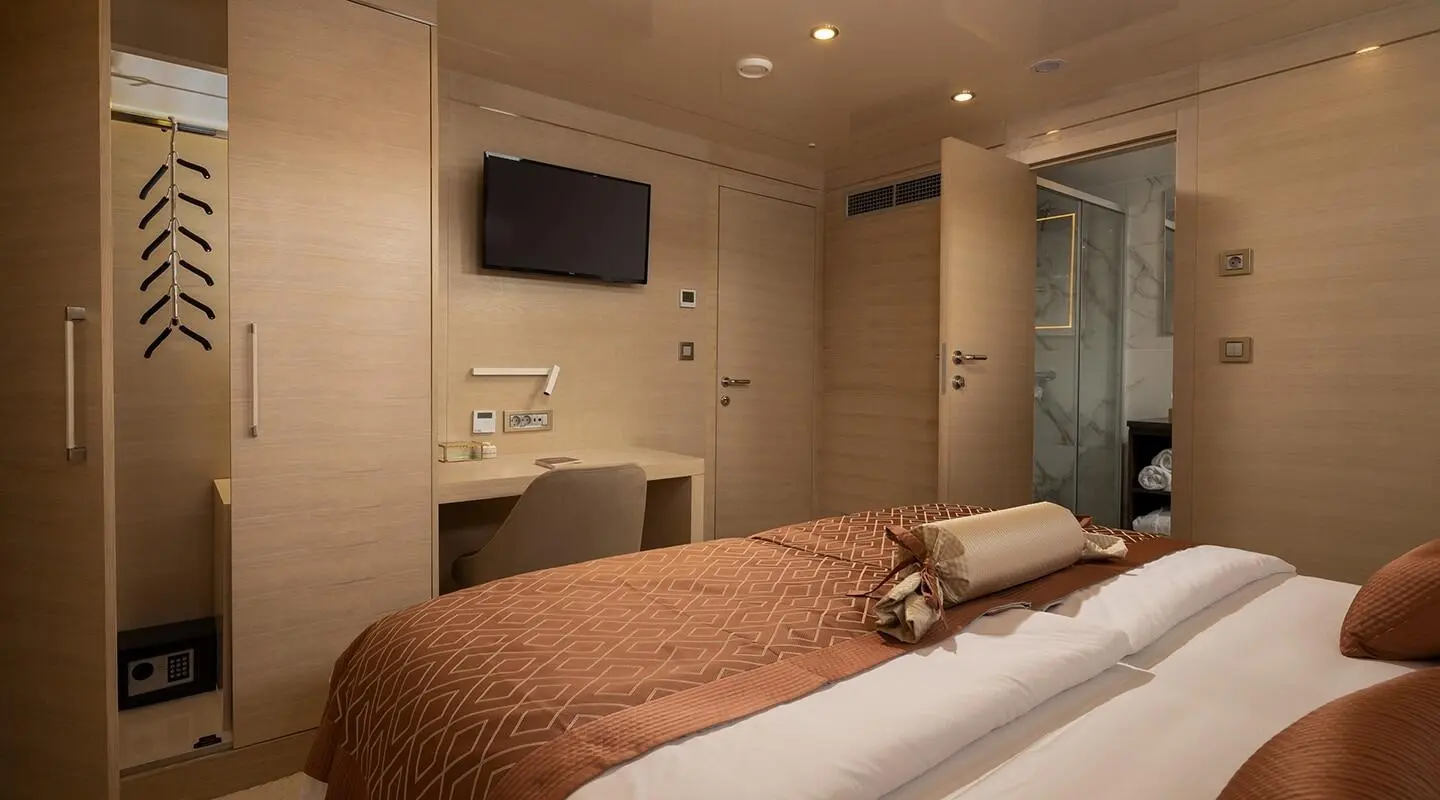 Luxurious yacht Love Story bedroom interior with bed, TV, and seating area