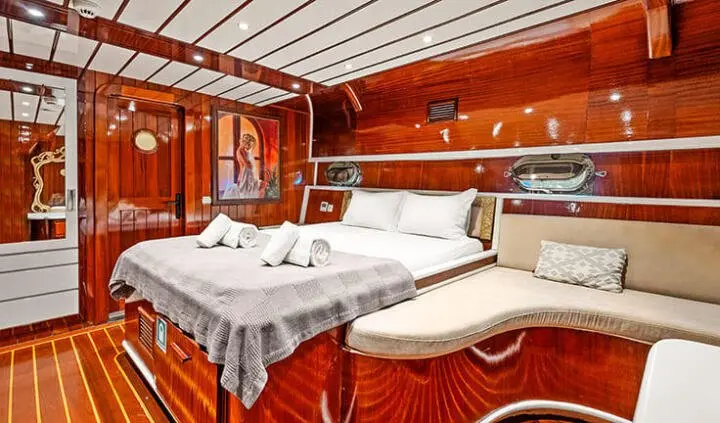 Esma Sultan yacht cabin with double bed, wood paneling, and portholes