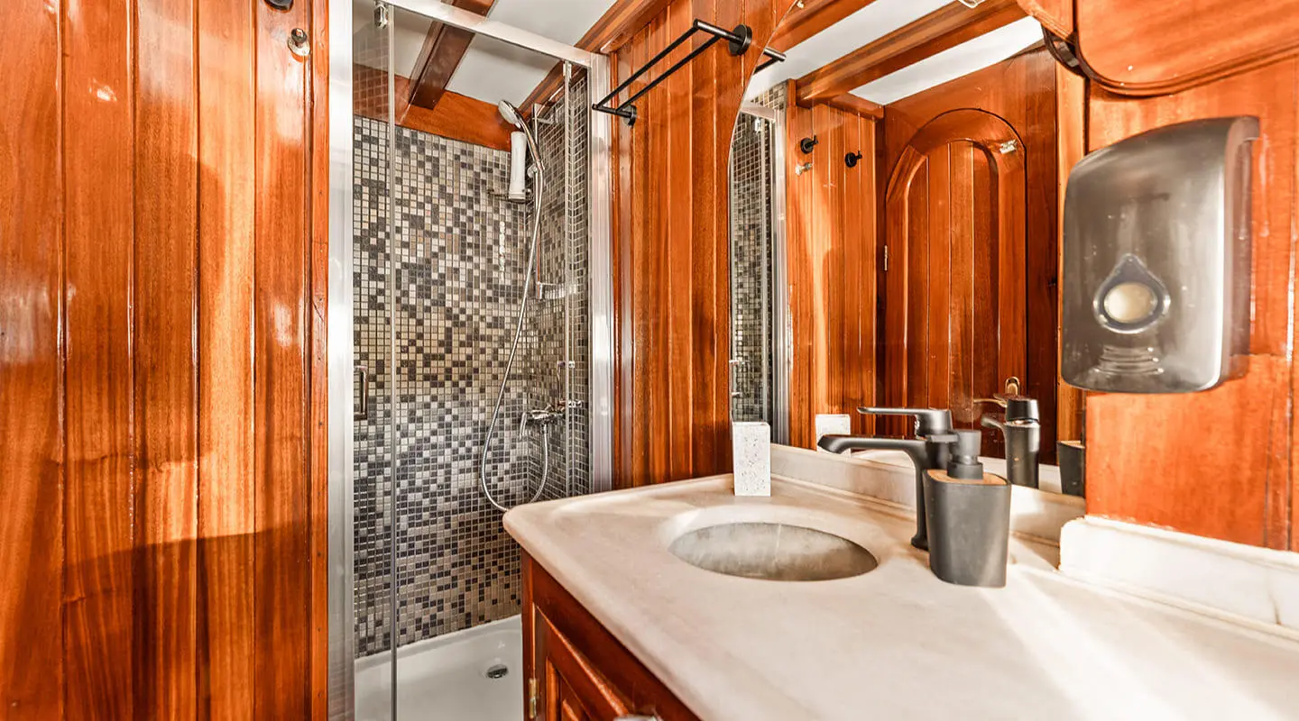Croatia yacht bathroom: polished wood paneling with mosaic tile shower and modern sink