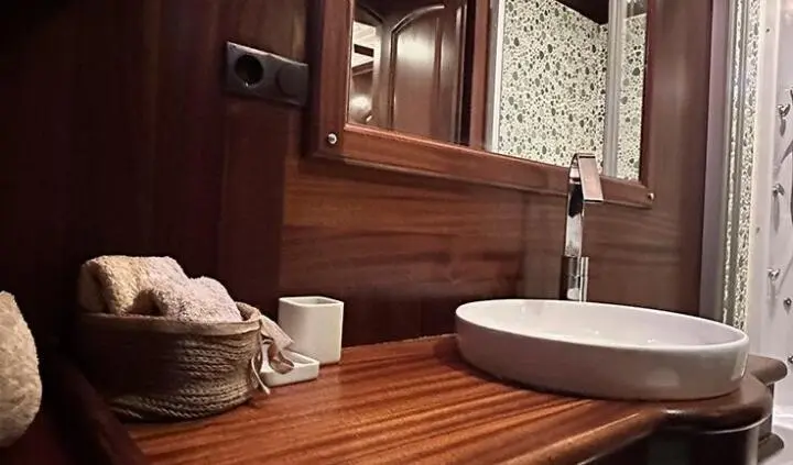 Master cabin with king bed, wooden cabinetry, ensuite area and round rug