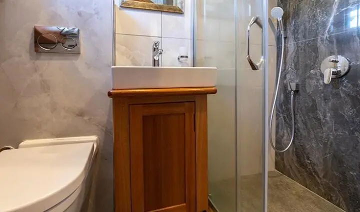 Bathroom sink area on Bodrum Queen yacht, wooden cabinet beside glass shower