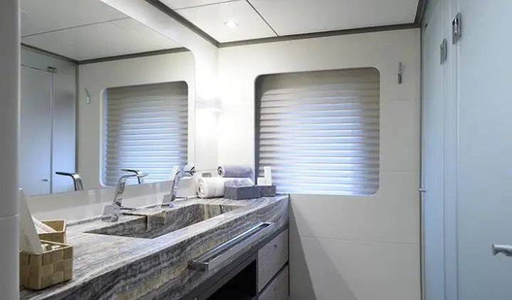 Glimpse of a yacht master cabin with king bed, ensuite, neutral tones
