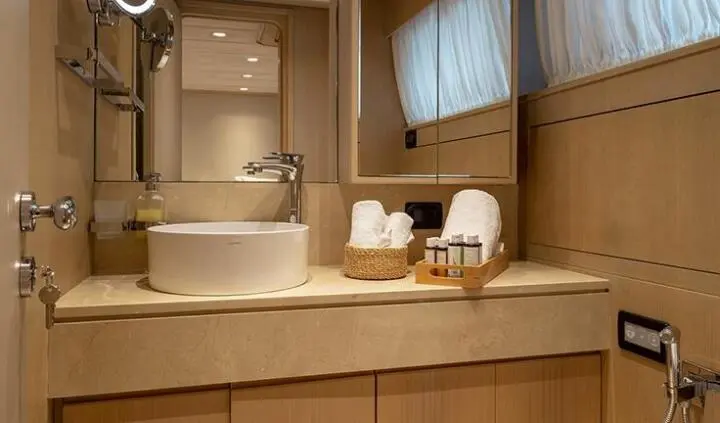 Master cabin with king bed, ensuite and wood tones, yacht interior
