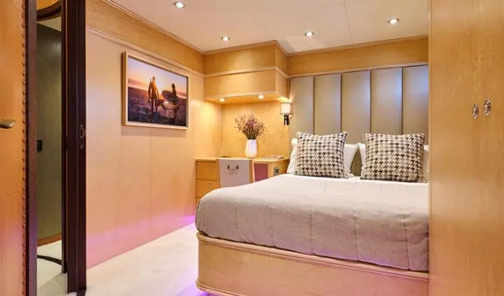 Mobius yacht cabin with king bed, ensuite view of bedside lamps and art