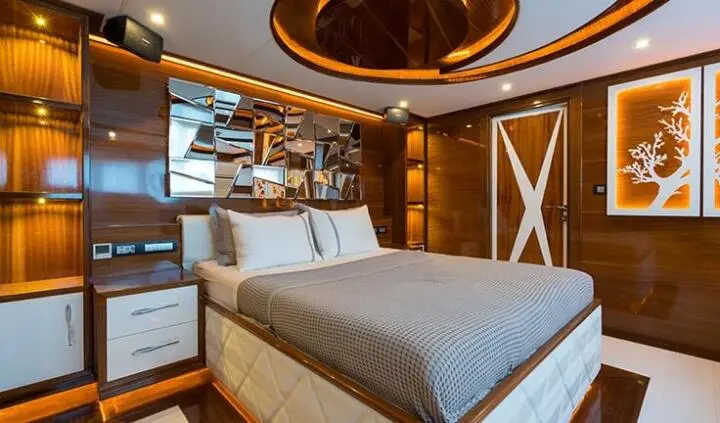 Master cabin with king bed, overhead lighting, and ensuite doorway