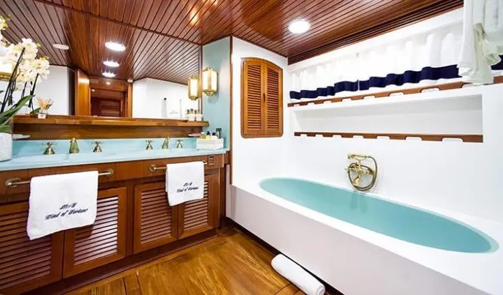 Wind Of Fortune yacht cabin interior with wood paneling, bed, and cabinetry