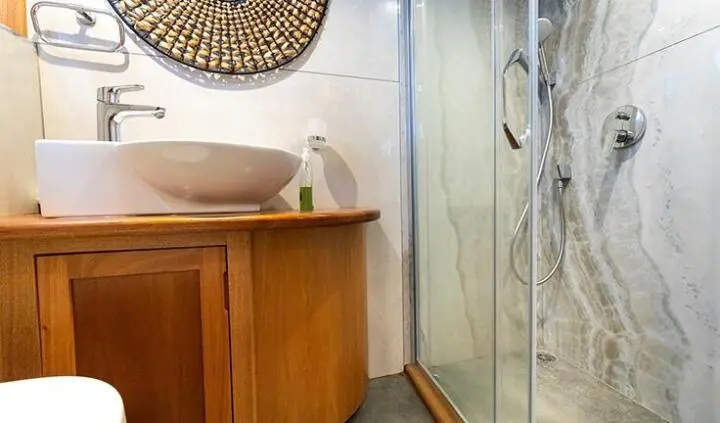 Master cabin with king bed, wooden cabinetry, ensuite shower, yacht interior