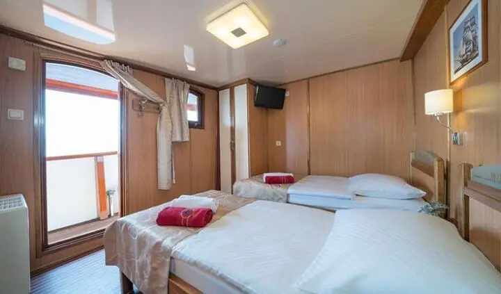 Twin cabin aboard Barbara yacht with two single beds and wooden cabinetry