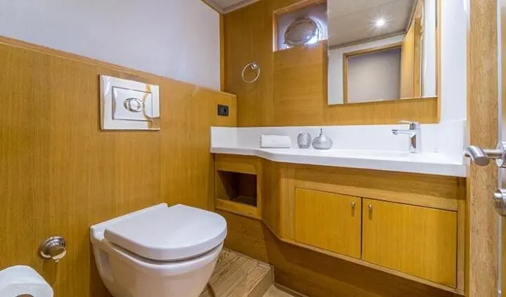 Master cabin with king bed, ensuite, wood cabinetry, porthole and mirror
