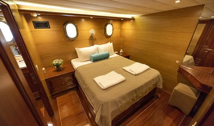 Kayhan 4 master cabin with king bed and ensuite, wood finish and portholes
