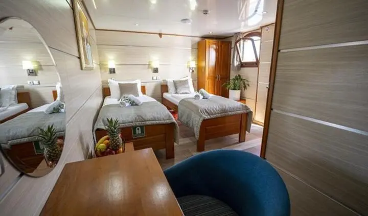 Twin-cabin yacht Karizma interior with two single beds and bedside lamps