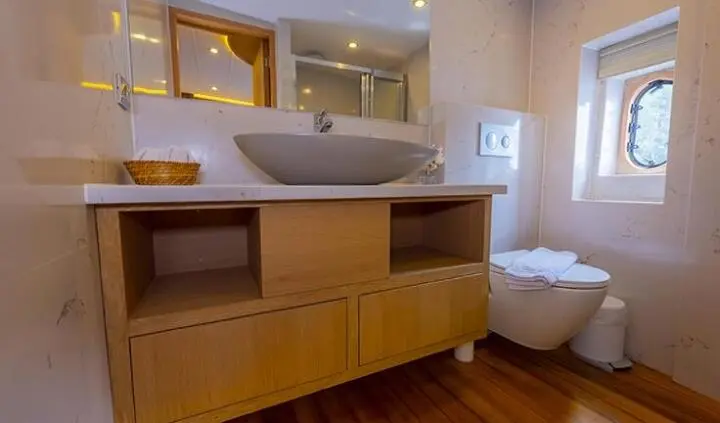 Master cabin with king bed and ensuite, wood cabinetry and bedside lamps