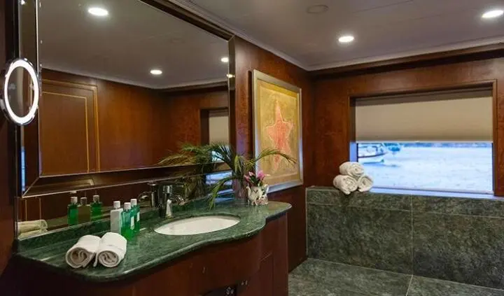 Ocean Breeze cabin ensuite interior with wooden panels, seating, and bed view