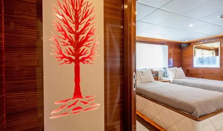 Long Island yacht cabin interior with twin beds, wood paneling, and soft lighting