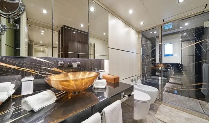 Luxurious master cabin with a wooden bed, plush seating, and modern en-suite bathroom