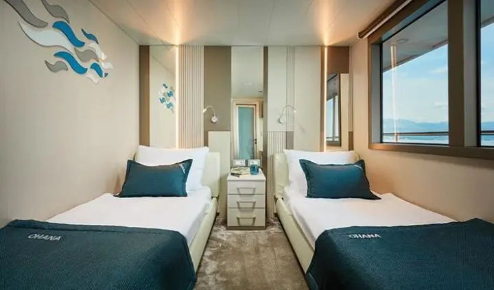 Ohana yacht twin cabin with two single beds, shared ensuite visible