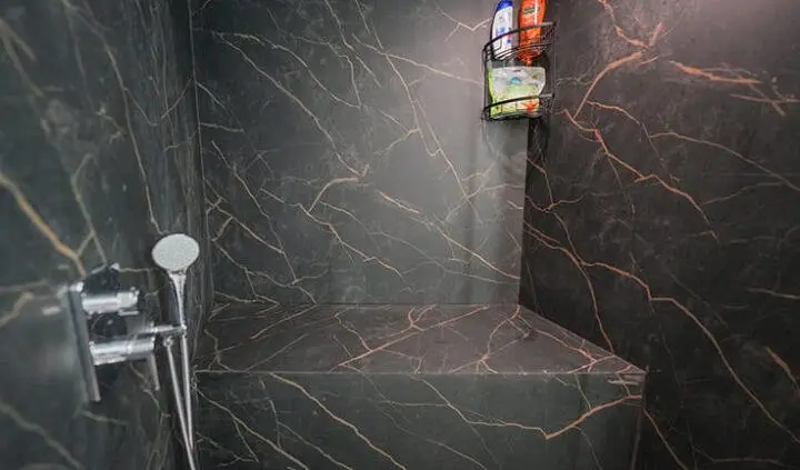 Master cabin shows a large bed with dark marble walls and a phone on the wall