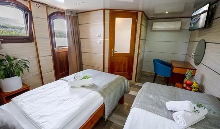 Twin cabin aboard Karizma with two single beds and wardrobe, daylight