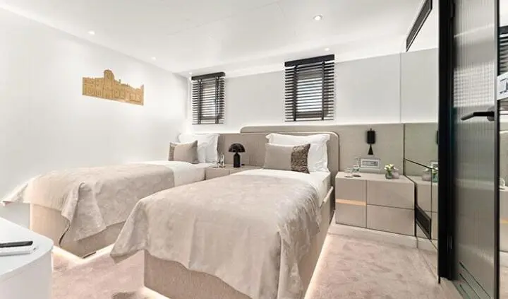 Twin cabin with ensuite beds on Maxita yacht, neutral decor and windows
