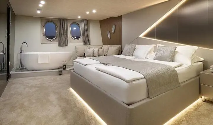 Cristal yacht cabin featuring a large bed, neutral tones, and ambient lighting
