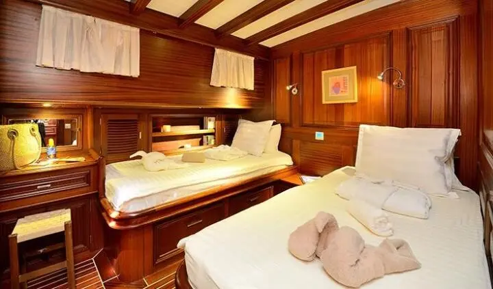 Twin cabin on Samarkand yacht with two beds and wooden paneling