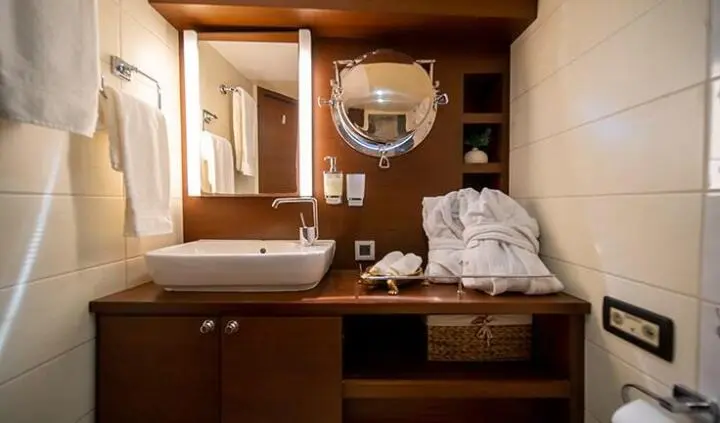 Master cabin with king bed, crisp white linens, and wooden cabinetry