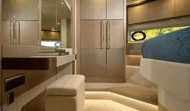 Interior cabin with king bed, ensuite entry, wood cabinets, neutral decor
