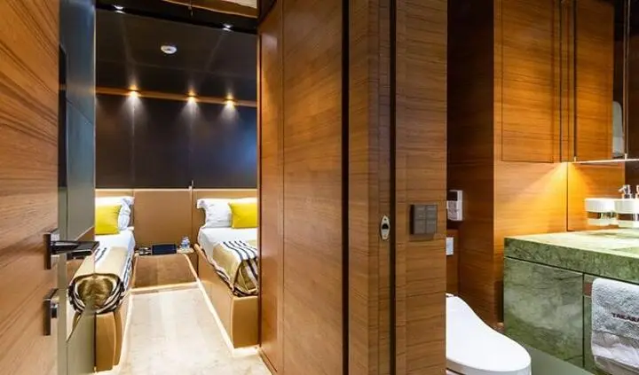 Takara One yacht cabin with two single beds, wood paneled walls, soft lighting