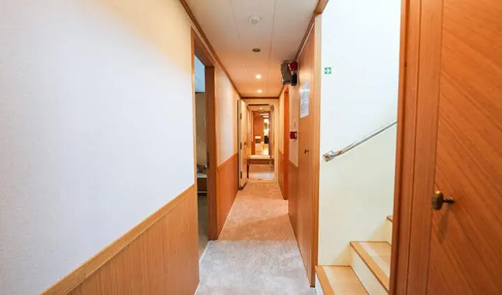 King Of The Sea cabin interior hallway leading to private staterooms and staircase