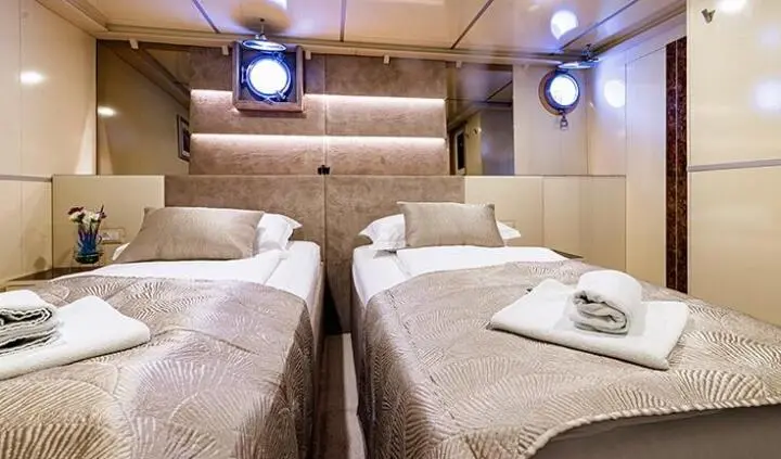 Twin-cabin ensuite aboard Melody yacht with neatly made beds and towels