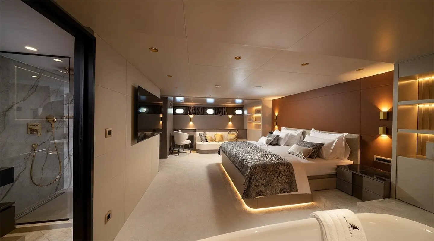 Nocturno luxury yacht bedroom with large bed, warm lighting, and suite decor