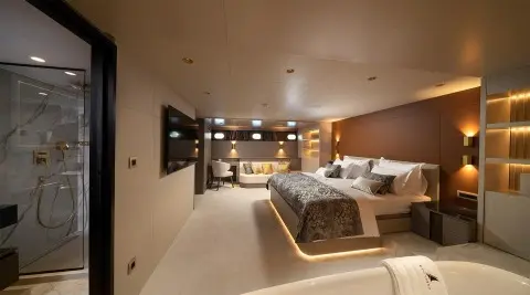 Nocturno luxury yacht bedroom with large bed, warm lighting, and suite decor