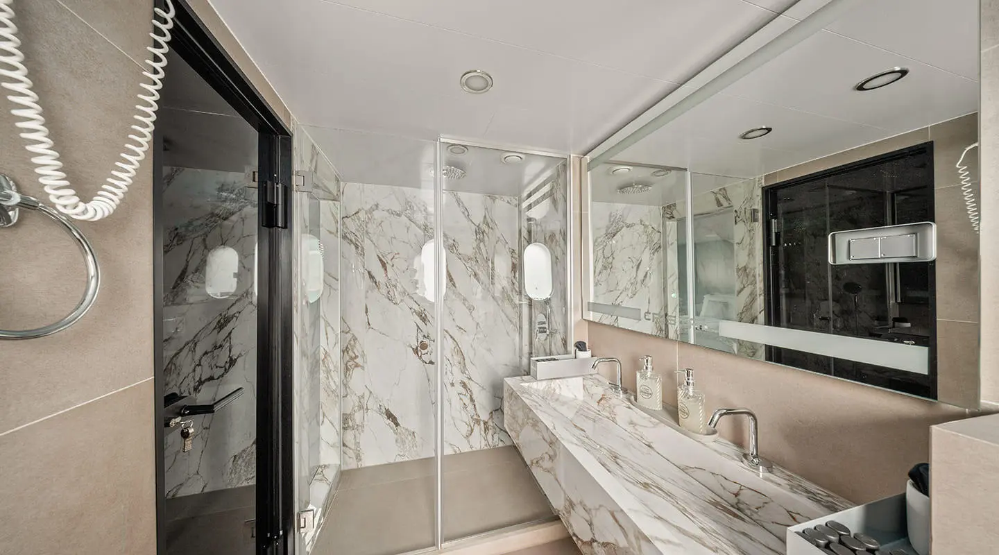 Luxurious marble bathroom aboard Cristal yacht, with glass shower and marble surfaces