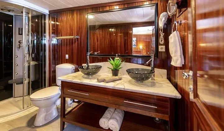 Cesarica yacht cabin with double bed, ensuite bathroom visible, warm wood tones