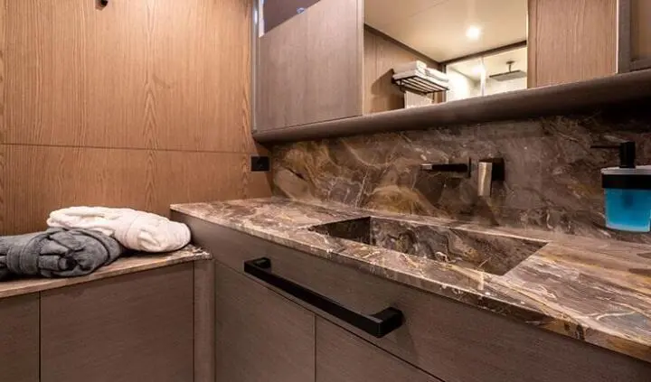 Master cabin with king bed and ensuite vanity, warm wood tones