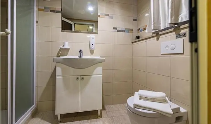 Melody yacht cabin with king bed, ensuite bathroom, beige tiling, sink, mirror