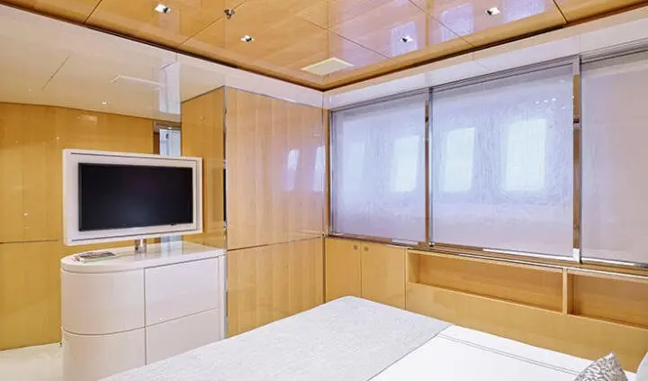 Master cabin with king bed, wood paneling, windows, and ensuite closet area