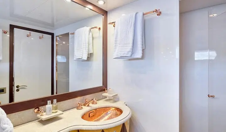 Mobius yacht cabin with king bed visible, ensuite bath area and towels