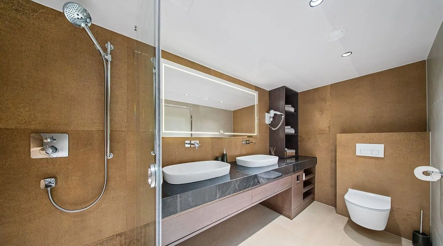 Anima Maris yacht bathroom with a single long white bench and round mirror