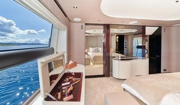 Master cabin with king bed, wood cabinetry, and ensuite bathroom seen on yacht Aluminia Too