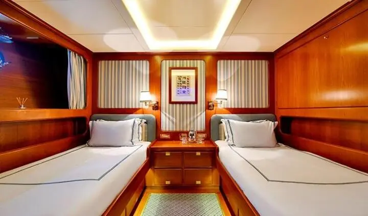 Twin cabin aboard Tamarita yacht with two single beds and wood trim