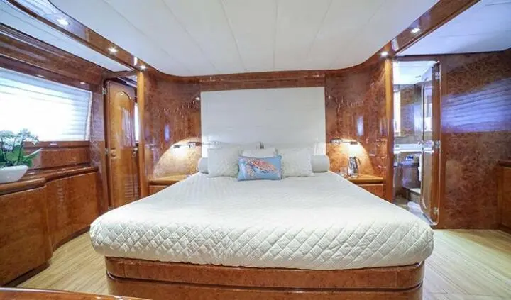 Yacht Zoi cabin with king bed, white bedding, wooden walls, lamps